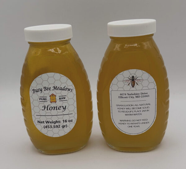 Two jars of Busy Bee Meadows Honey from Howard County Beehives on a white background.